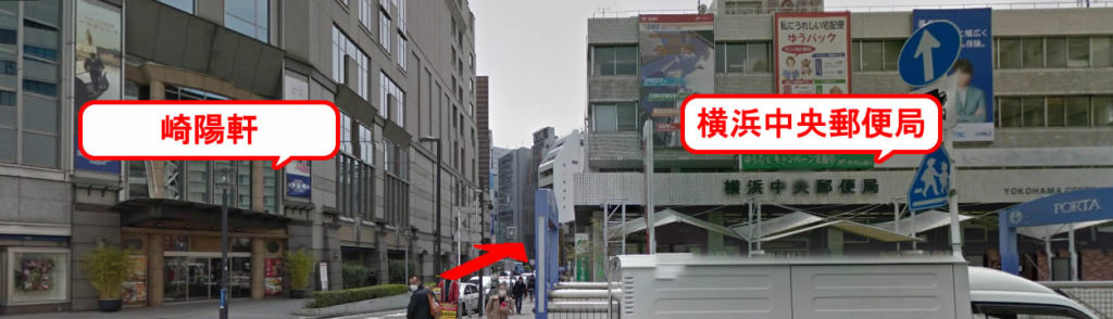 横浜駅東口の階段を上がり、横浜中央郵便局へ向かってください。崎陽軒と中央郵便局の間の道を、まっすぐ進みます。